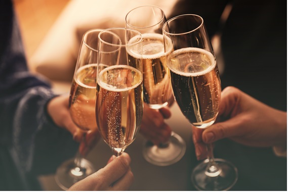 4人がスパークリングワインで乾杯している画像